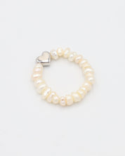 A ring bracelet with a heart-shaped clasp and white pearl-like beads.