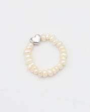 A silver ring with a heart-shaped clasp and white pearl-like beads.