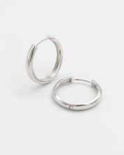 A pair of silver hoop earrings with a hinged clasp, displayed on a white background.