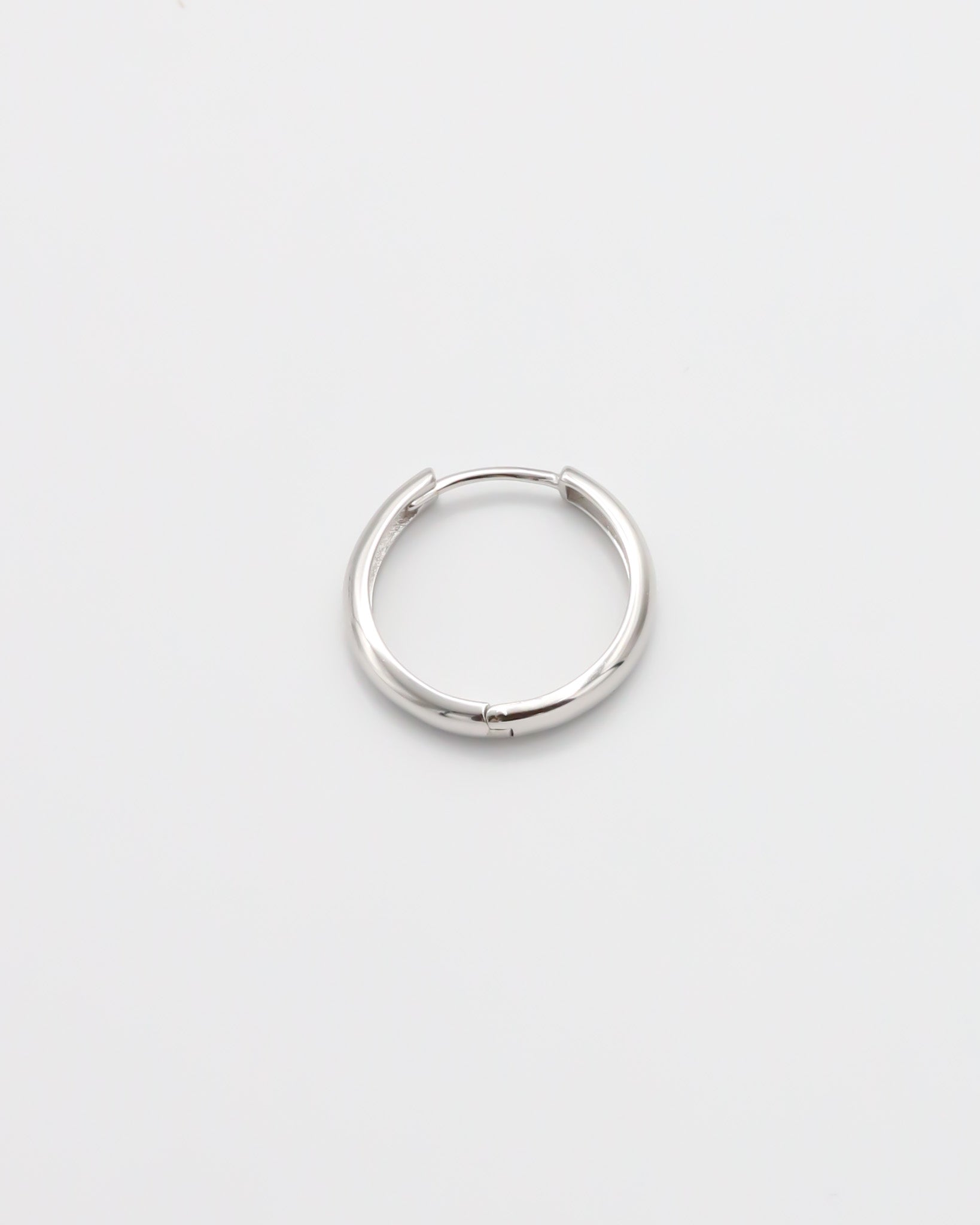 A single silver hoop earring with a hinged clasp, displayed on a white background.