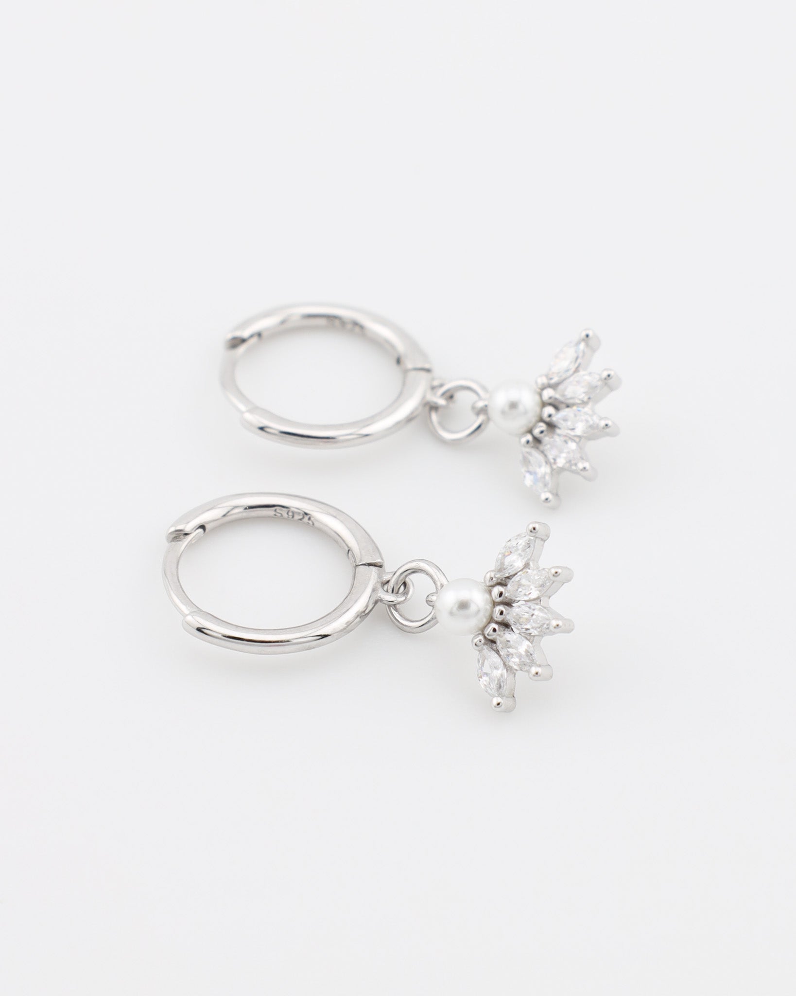 Pair of silver hoop earrings with star-shaped charms on a white background