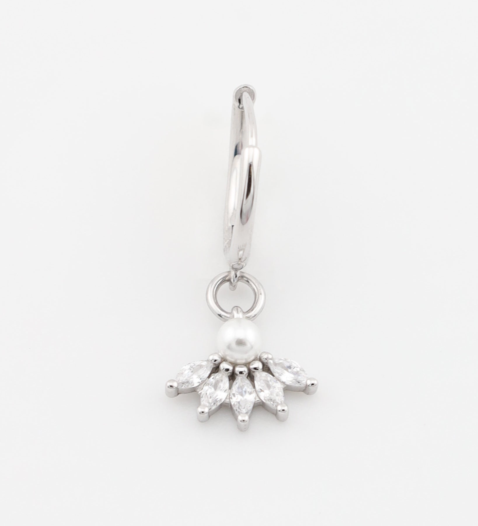 Silver earring with a pearl and clear stones on a white background