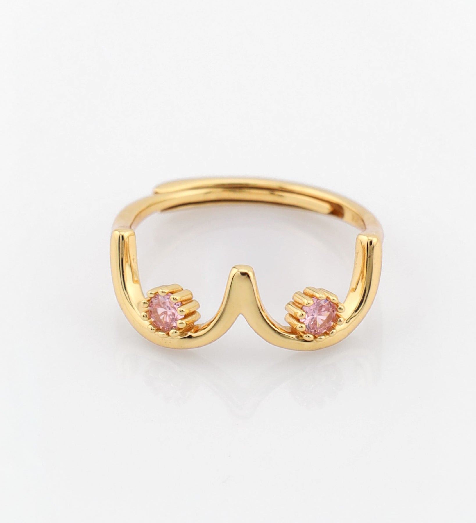 Gold ring with pink gemstones on a white background