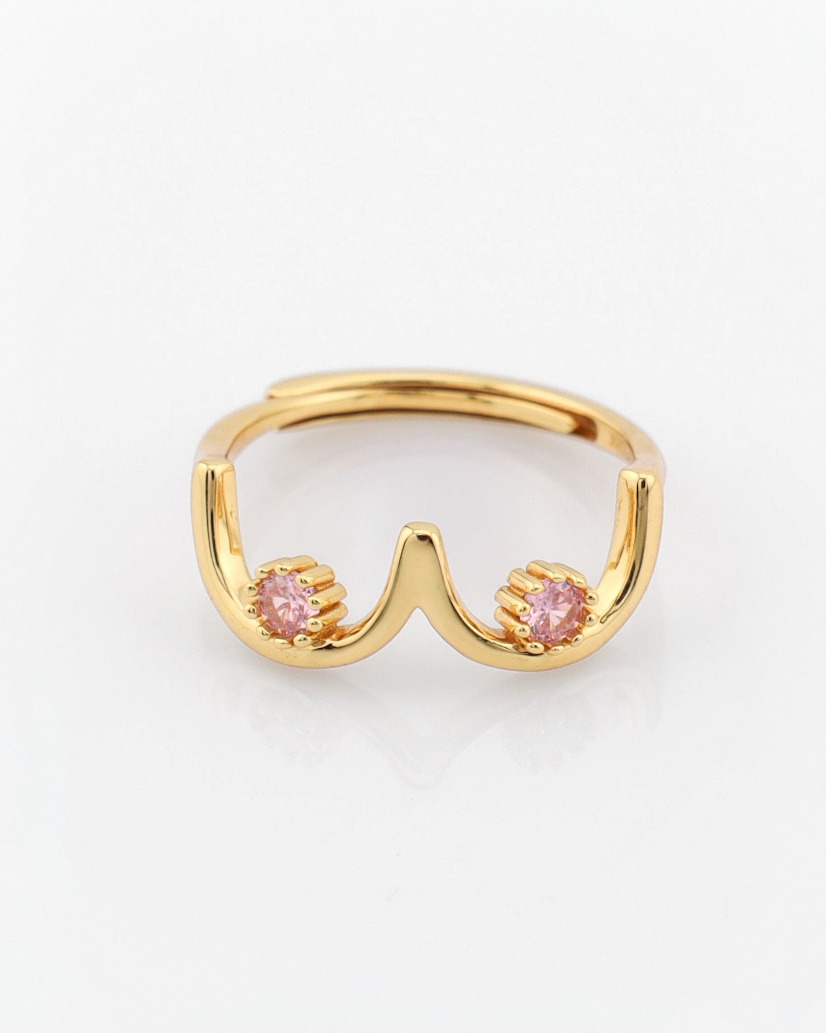 Gold ring with pink gemstones on a white background