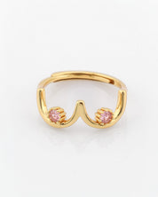 Gold ring with pink gemstones on a white background