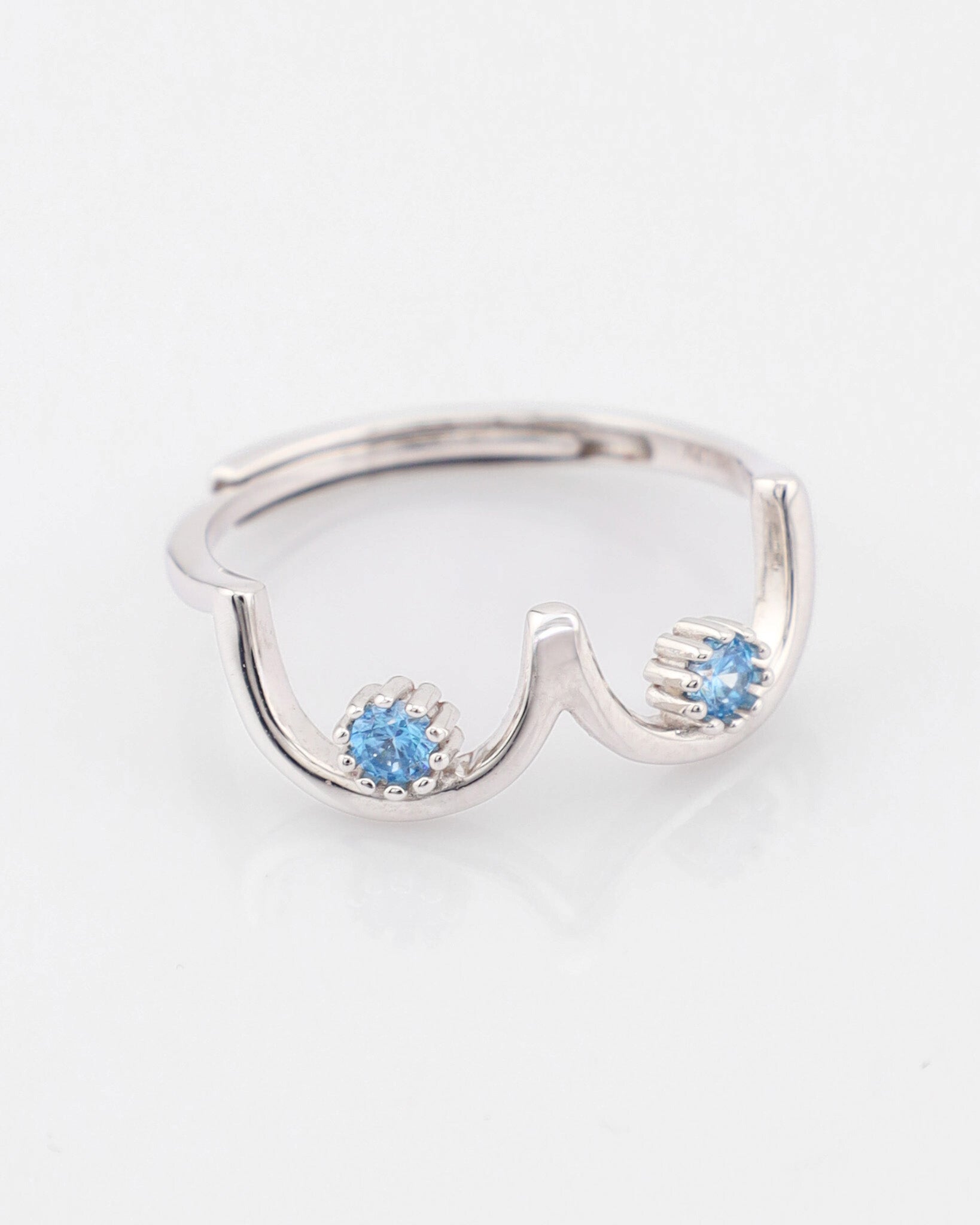 Silver ring with blue gemstones on a white background