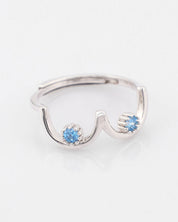 Silver ring with blue gemstones on a white background