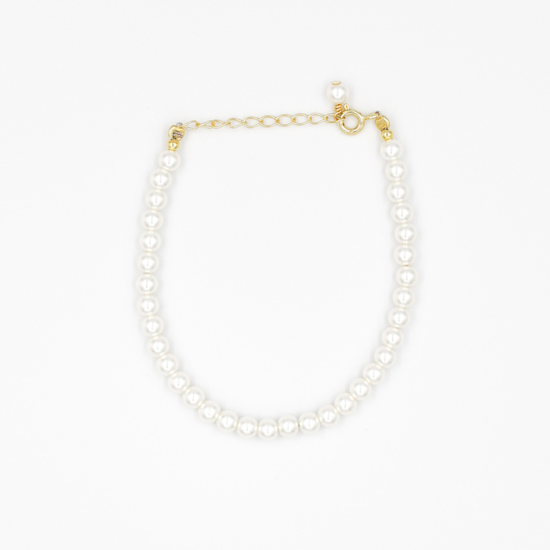 A gold-colored necklace featuring a series of size large pearl beads and a small gold chain.
