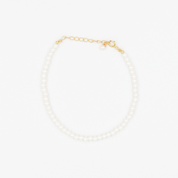 A gold-colored necklace featuring a series of size medium pearl beads and a small gold chain.