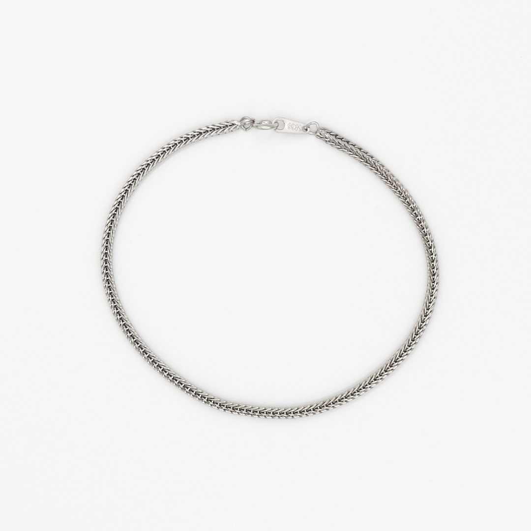 A silver necklace on a white background.