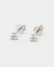 A single silver stud earring with a butterfly clasp, featuring a small spherical design.