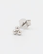 A single silver stud earring with a butterfly clasp, featuring a small spherical design.