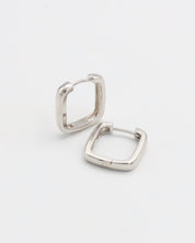 A pair of silver-colored hoop earrings with a hinged clasp, displayed against a white background.