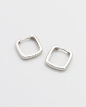 A pair of silver-colored hoop earrings with a hinged clasp, displayed against a white background.