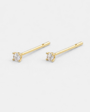 Gold stud earrings with clear gemstones on a white background