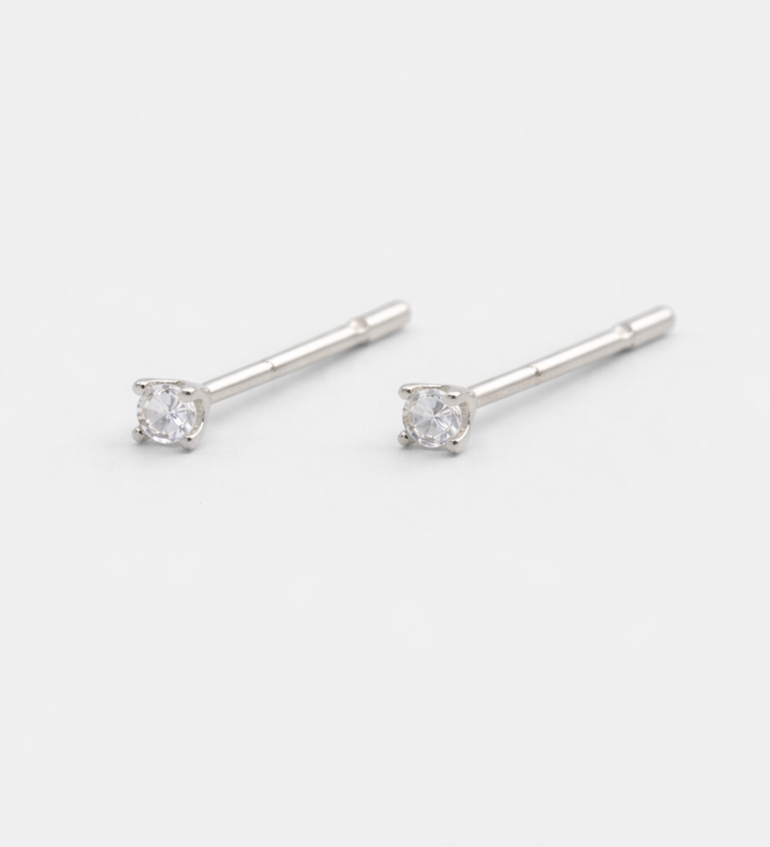 Silver stud earrings with clear gemstones on a white background