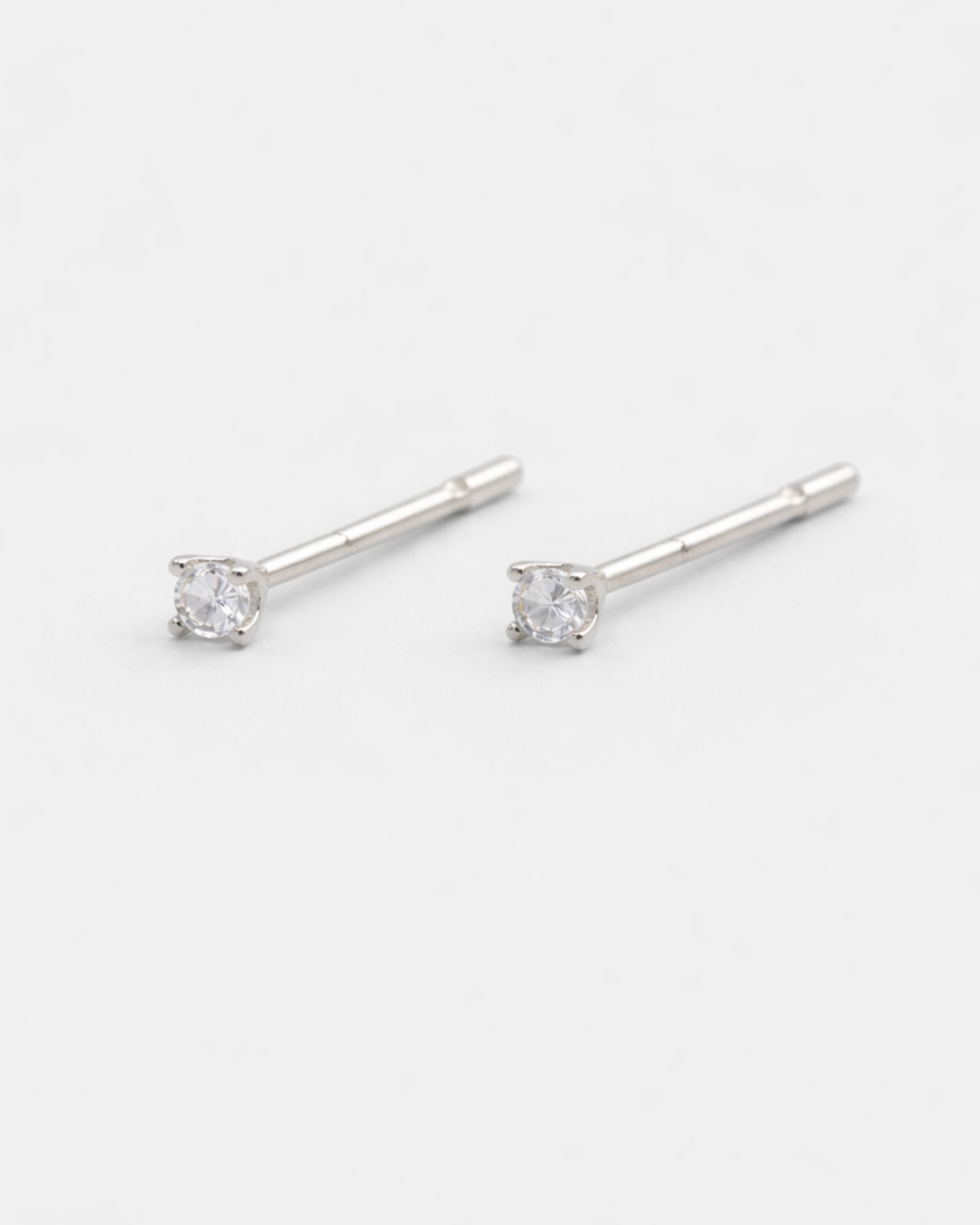 Silver stud earrings with clear gemstones on a white background