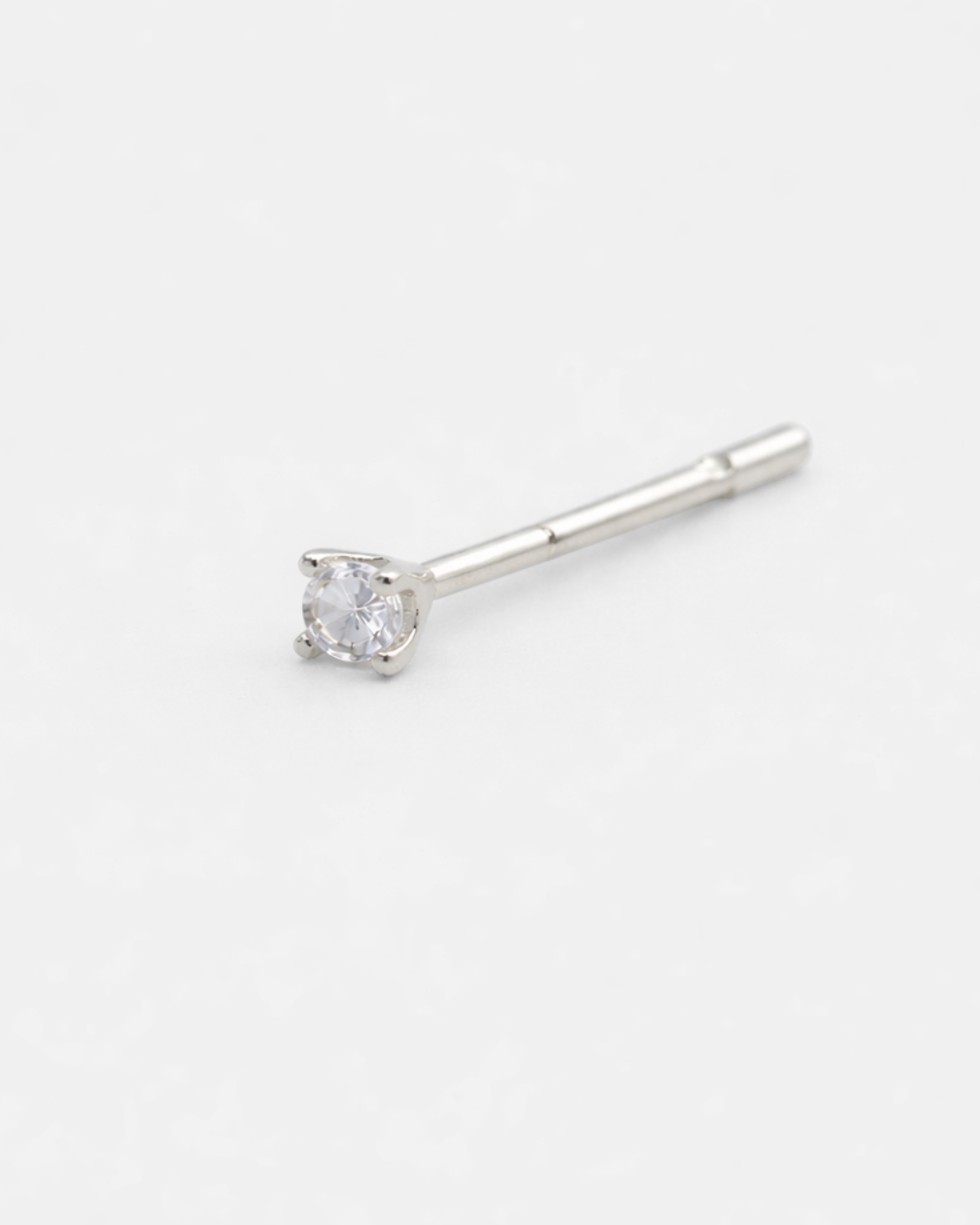 Silver stud earring with a clear gemstone on a white background