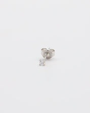 A single silver stud earring with a small clear gemstone, displayed against a white background.