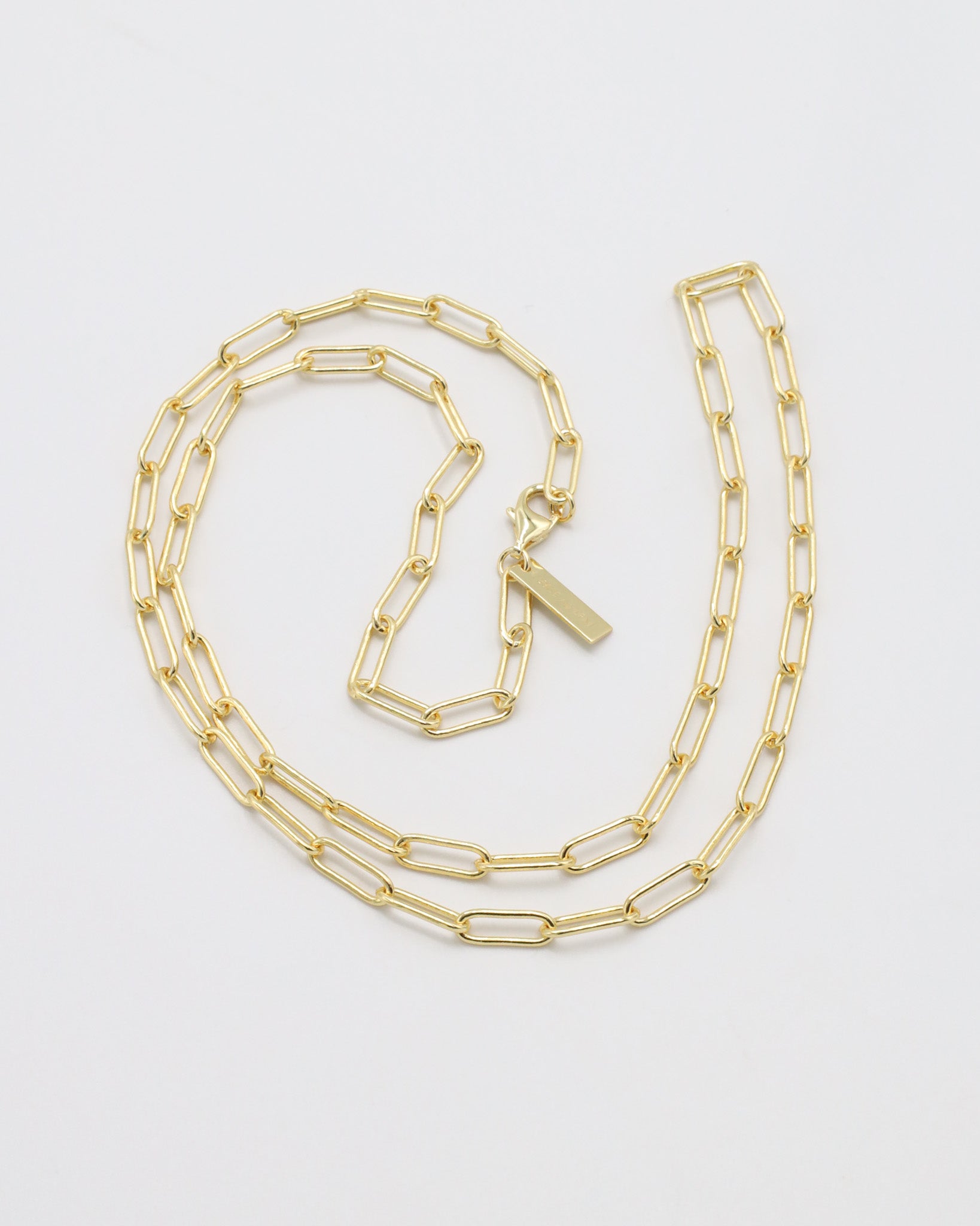 Gold chain necklace on a light gray background