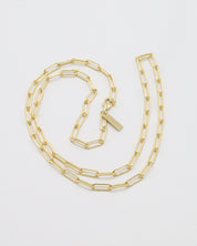 Gold chain necklace on a light gray background