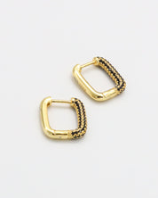 A single gold-colored hoop earring with black accents and a hinged clasp.