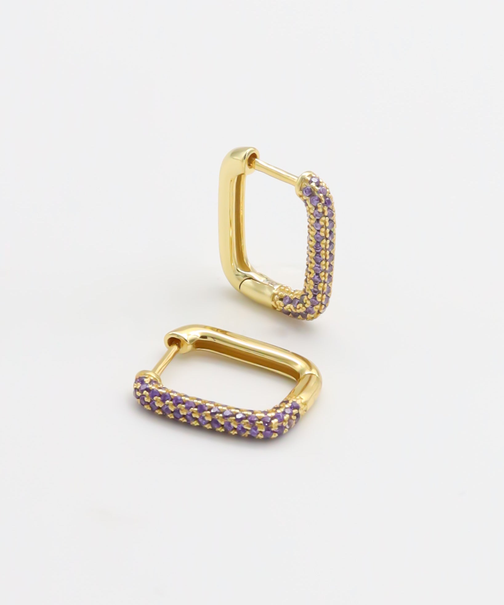 A single gold-colored hoop earring with purple accents, presented against a white background.