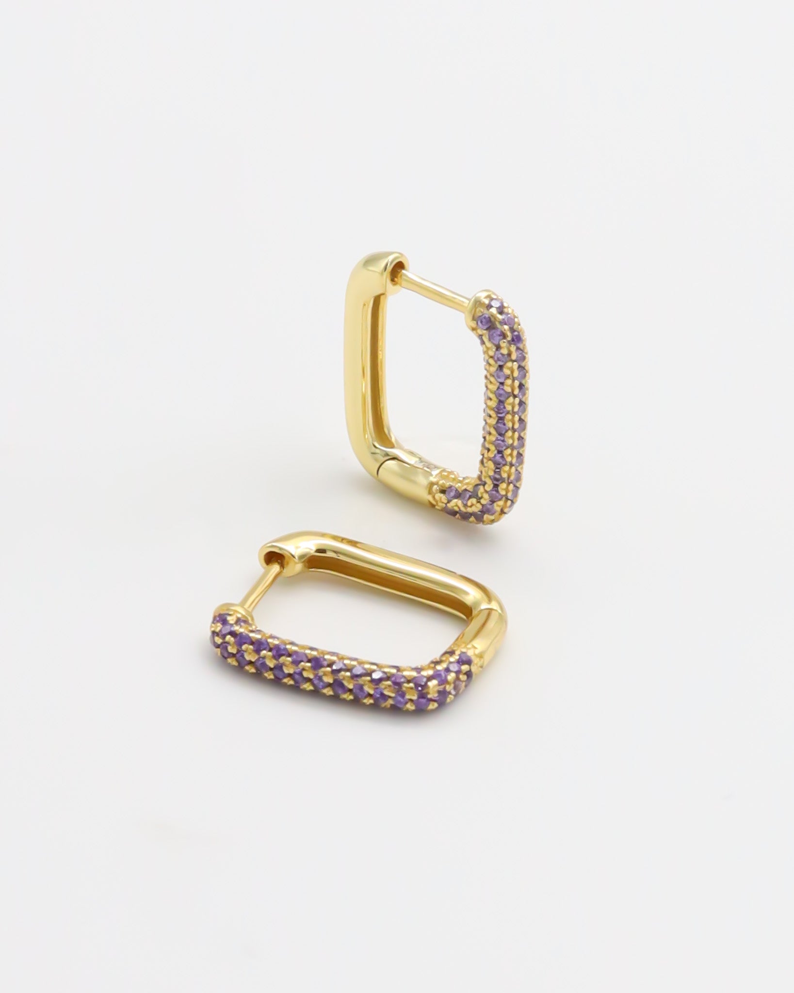 A single gold-colored hoop earring with purple accents, presented against a white background.