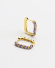 A single gold-colored hoop earring with purple accents, presented against a white background.
