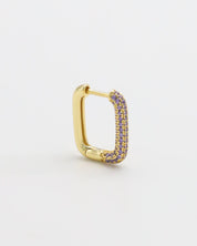 A single gold-colored hoop earring with purple accents, presented against a white background.
