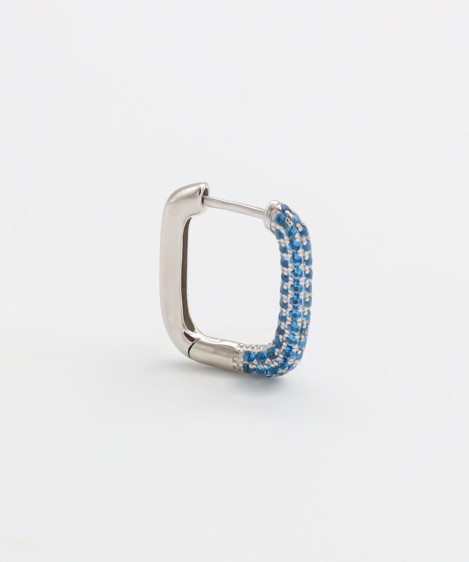 A silver hoop earring with blue accents, featuring a hinged closing mechanism.
