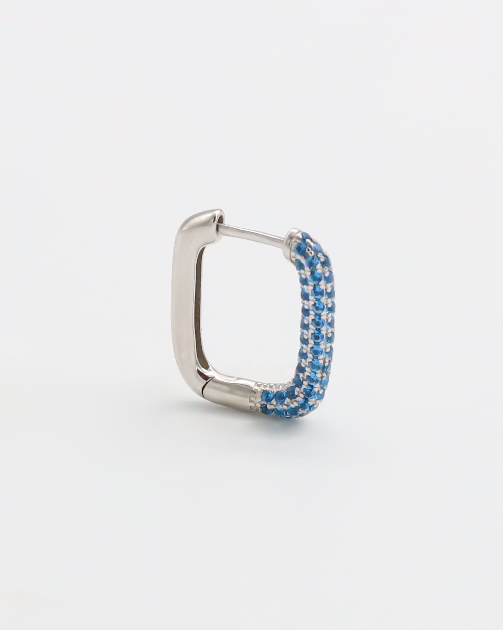 A silver hoop earring with blue accents, featuring a hinged closing mechanism.