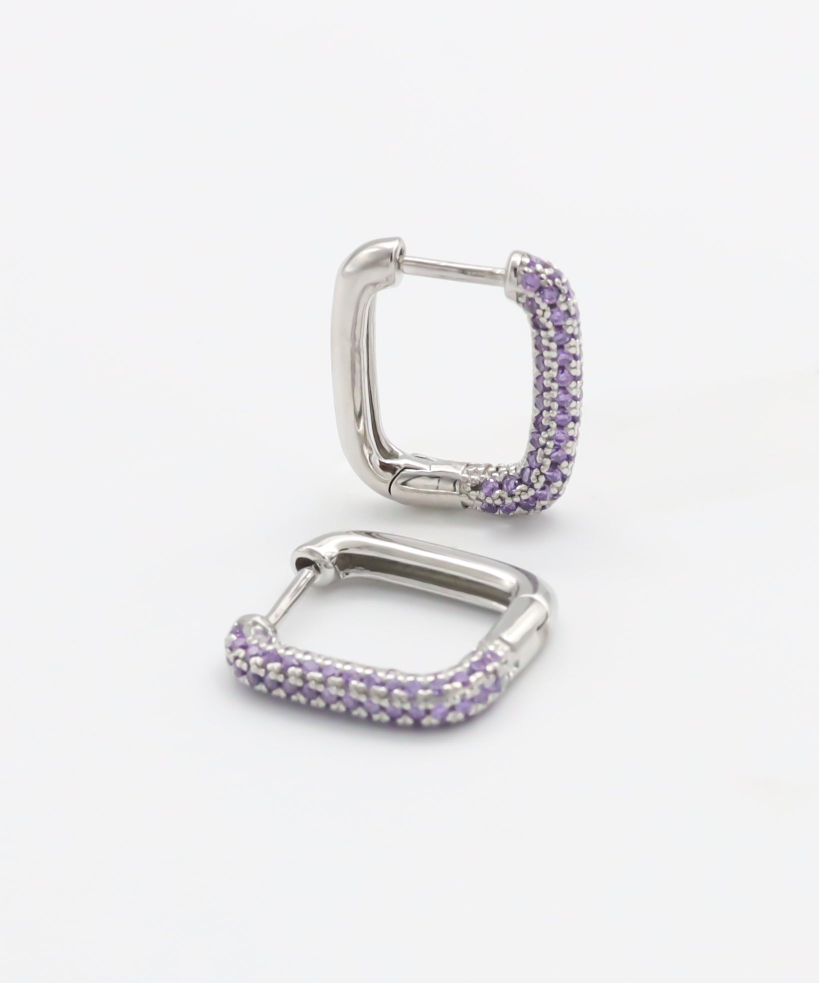 A single silver hoop earring with a hinged clasp and purple gemstone detailing.