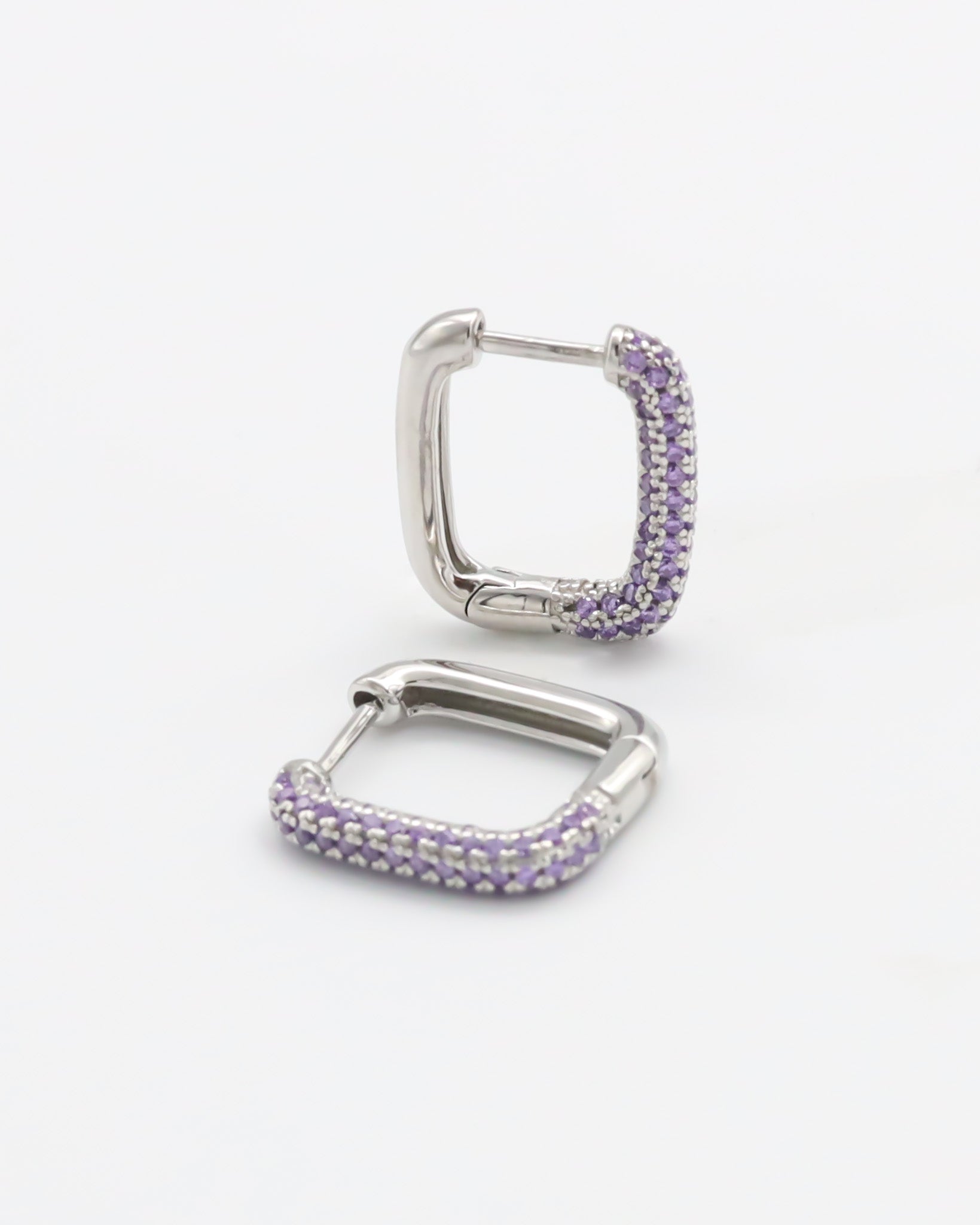 A single silver hoop earring with a hinged clasp and purple gemstone detailing.