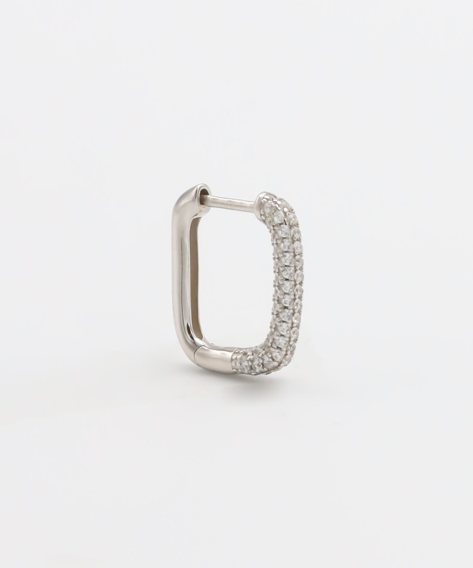 A silver hoop earring with a hinged clasp, featuring a row of small, embedded stones around the hoop.
