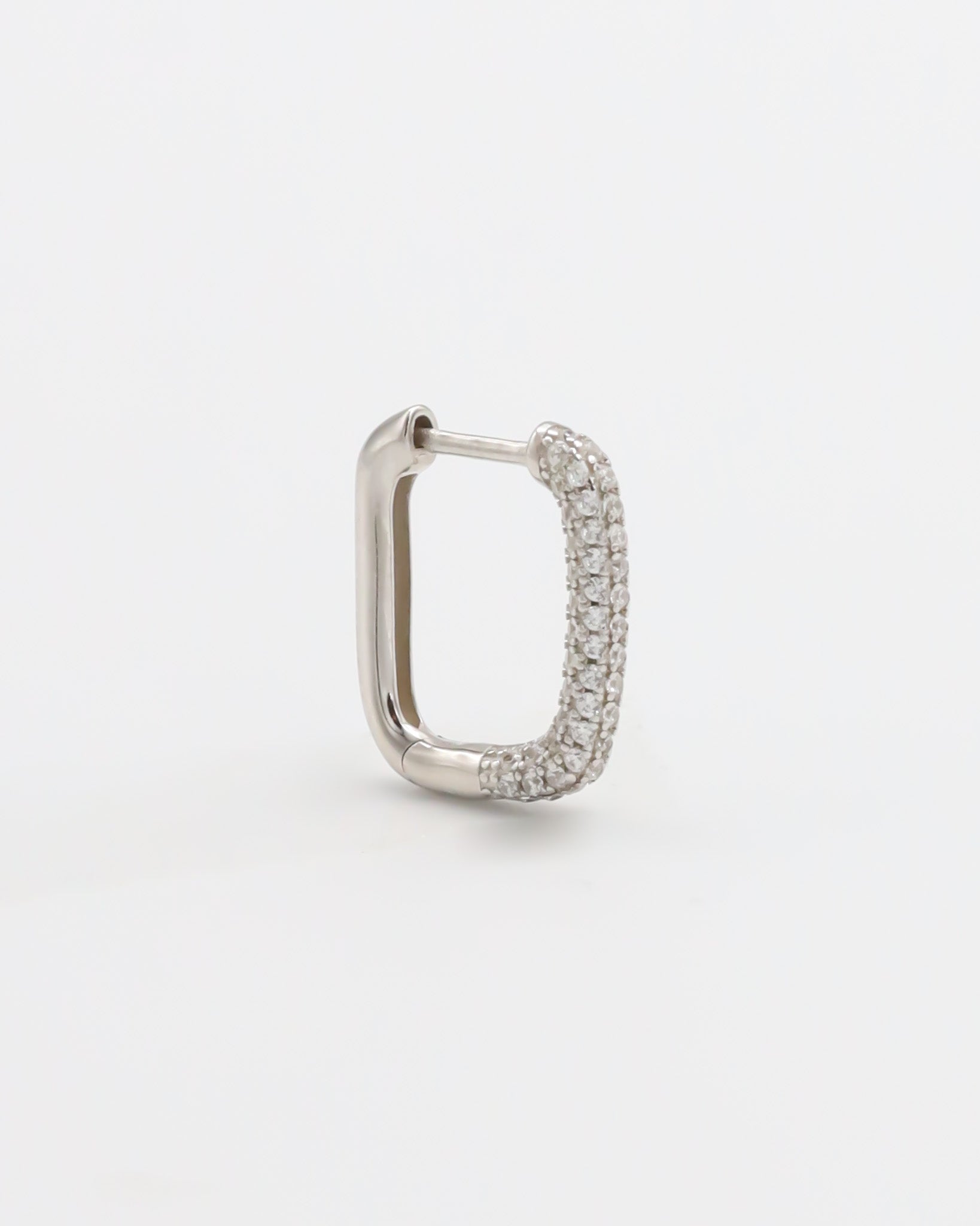 A silver hoop earring with a hinged clasp, featuring a row of small, embedded stones around the hoop.