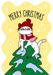 Illustrated Christmas postcard featuring a cute white cat wearing a red hat and a red-pink striped scarf. The cat is playfully sitting on top of a decorated Christmas tree with blue snow patches and red heart ornaments. The background is yellow with white star-shaped sparkles, and the greeting “MERRY CHRISTMAS” is written in bold black letters above the cat.