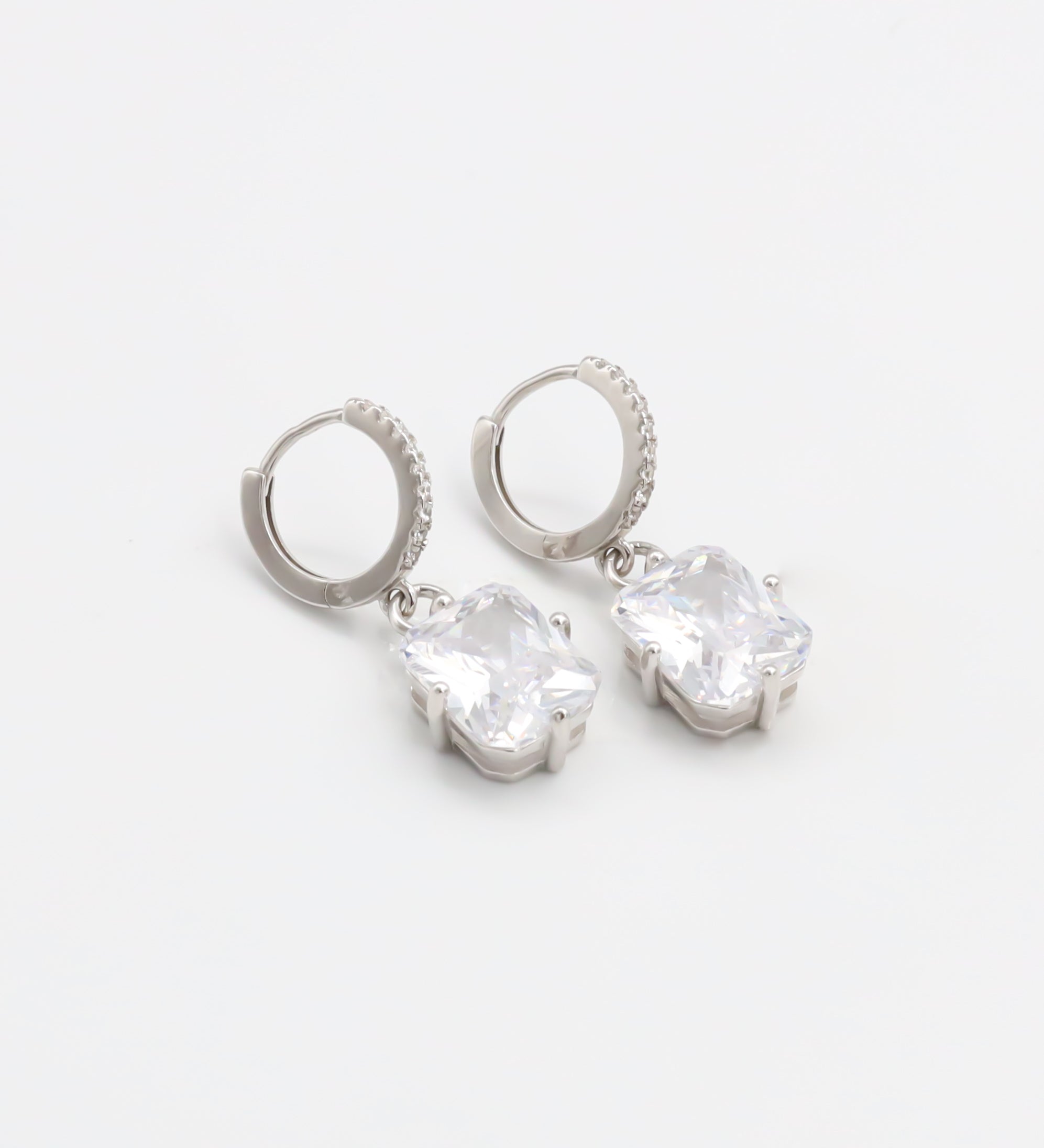 A pair of sterling silver hoop earrings with a hinged clasp and clear cubic zirconia stones.