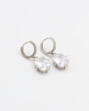 A pair of sterling silver hoop earrings with a hinged clasp and clear cubic zirconia stones.