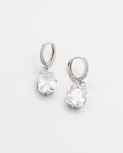 A pair of sterling silver hoop earrings with a hinged clasp and clear cubic zirconia stones.