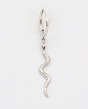 A silver hoop earring with a small silver charm shaped like a snake dangling from it.