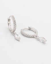 A silver hoop earring with a hinged clasp, decorated with small white gemstones along its length, displayed against a white background.