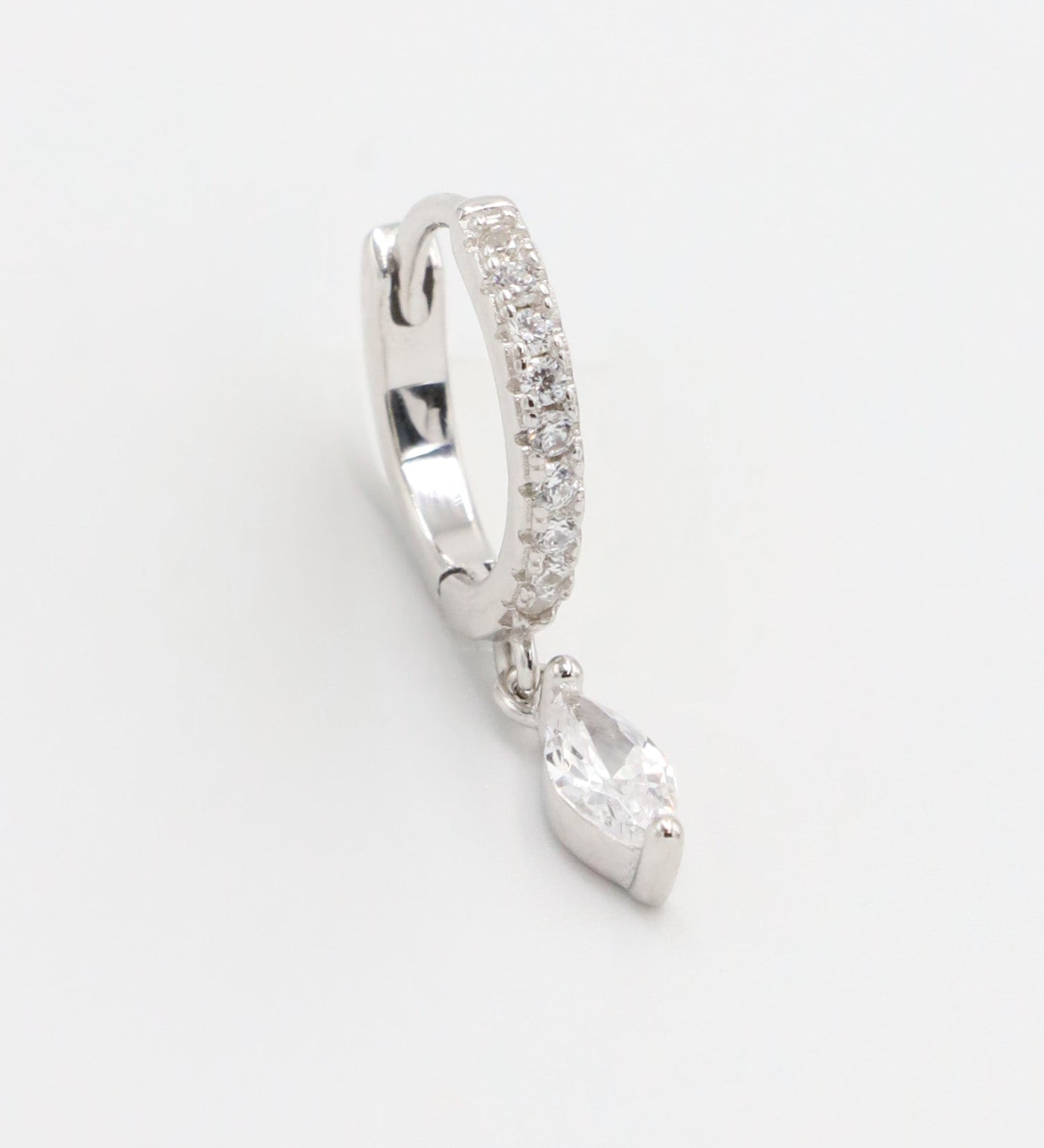 Silver hoop earring with a heart-shaped pendant on a white background