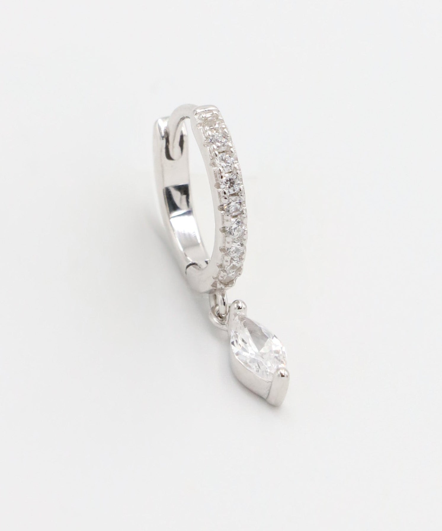 Silver hoop earring with a heart-shaped pendant on a white background