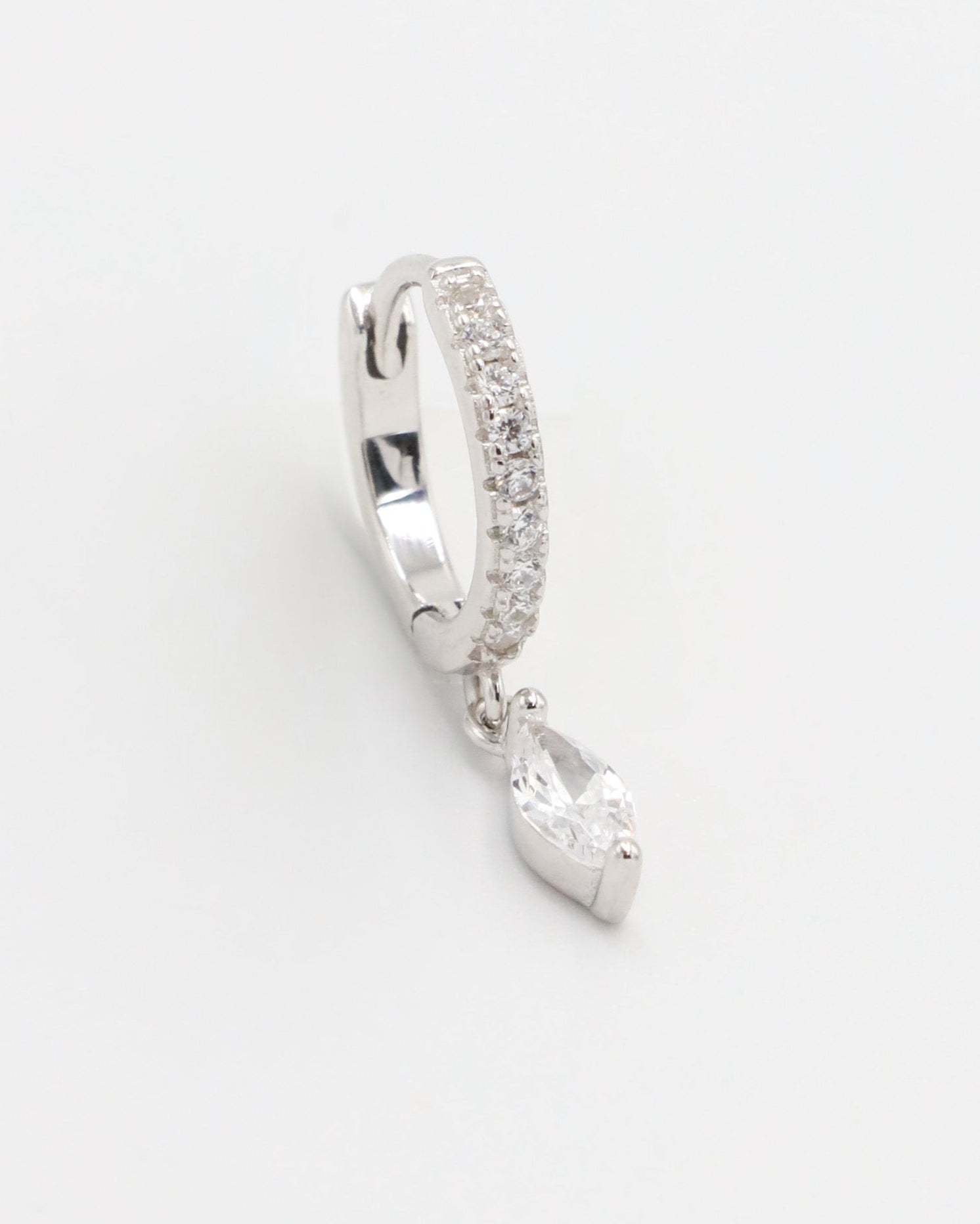 Silver hoop earring with a heart-shaped pendant on a white background