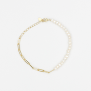 A two-tone gold bracelet with one half featuring smooth gold links and the other half with pearl beads, displayed against a white background.