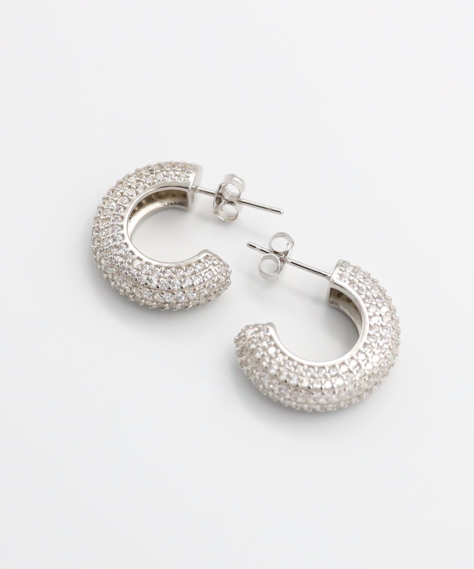 A pair of silver hoop earrings with a butterfly clasp closure.