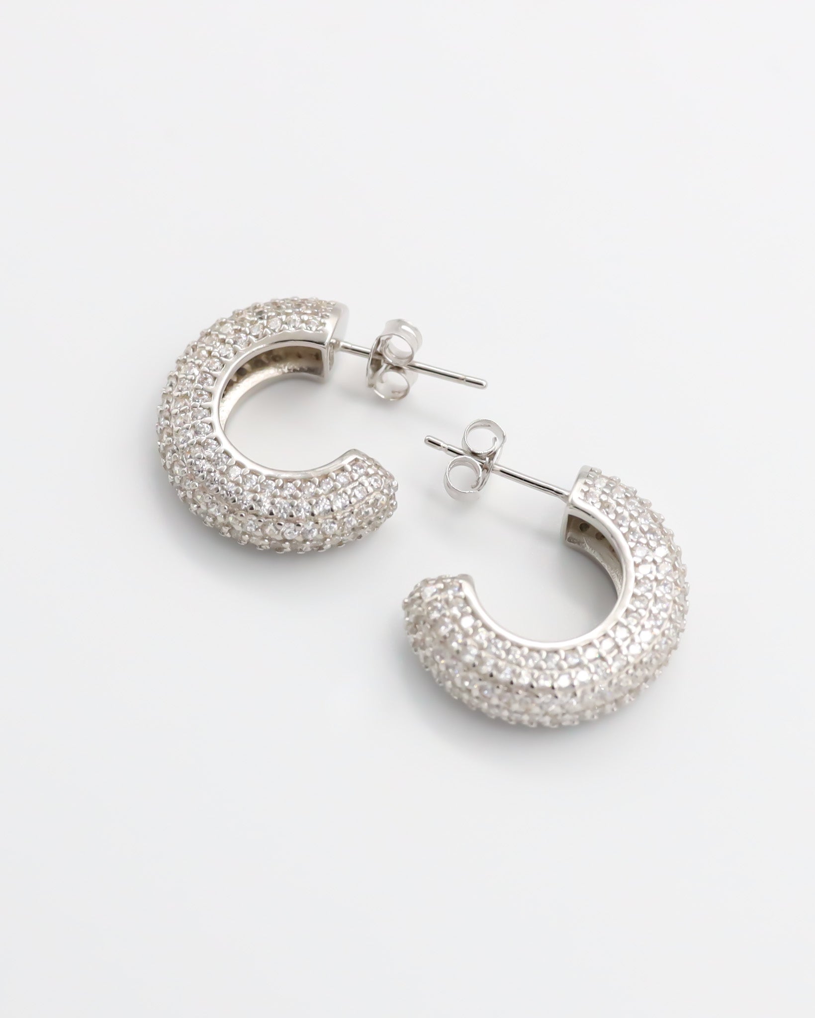 A pair of silver hoop earrings with a butterfly clasp closure.