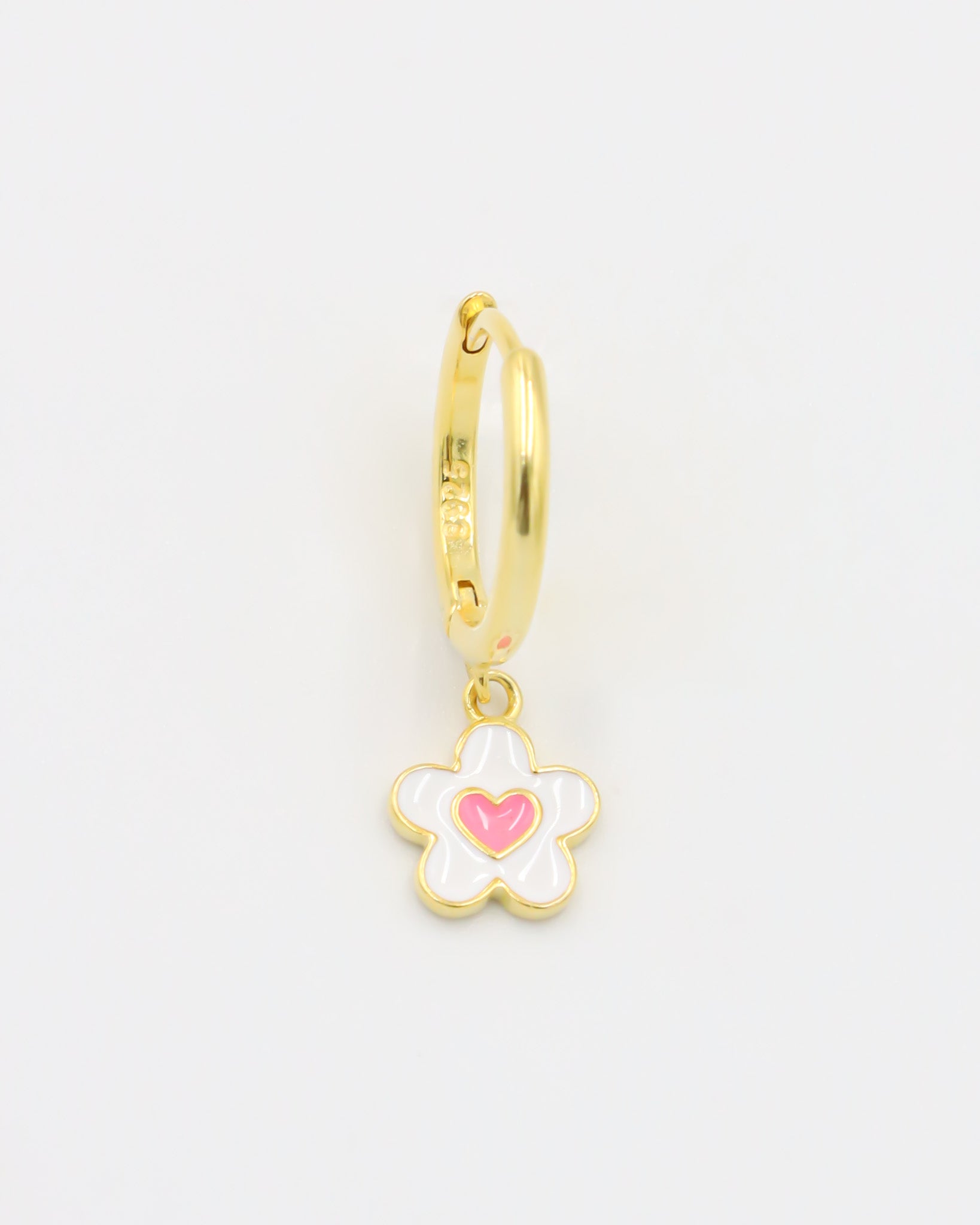 A gold-colored hoop earring with a white and gold flower-shaped charm attached to it.