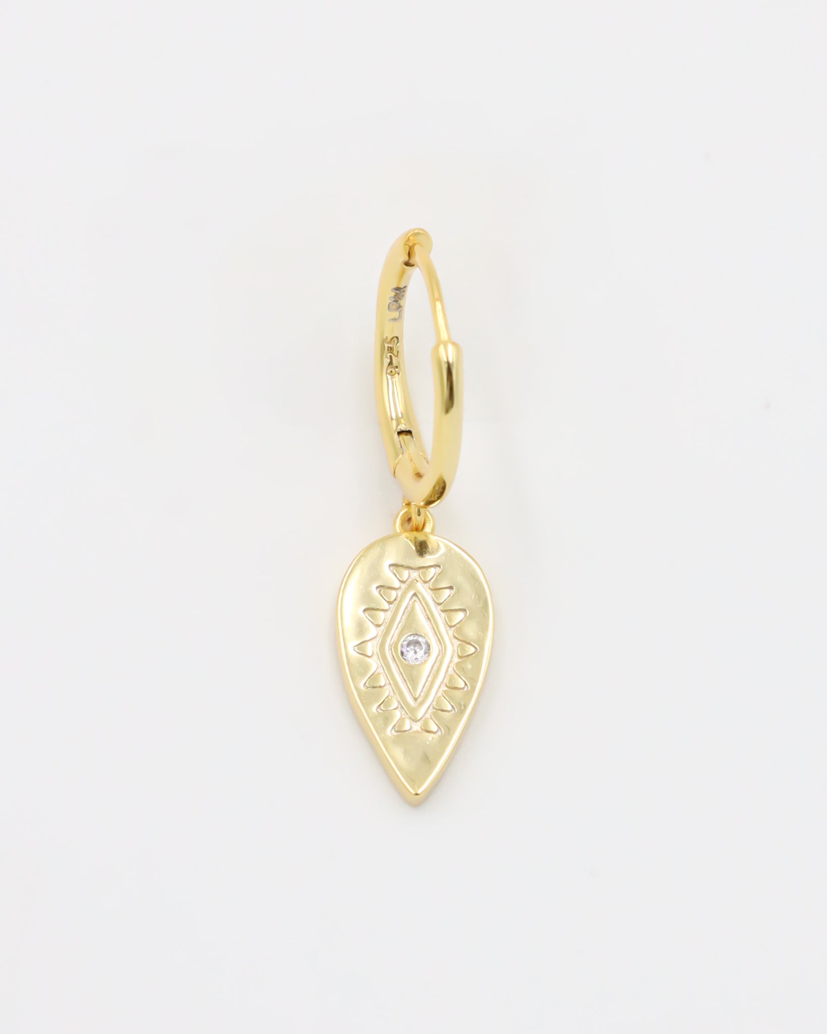 A single gold hoop earring with a hinged clasp and a dangling, ornate, gold heart-shaped charm.